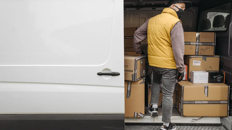 Courier preparing boxed deliveries inside a cargo van